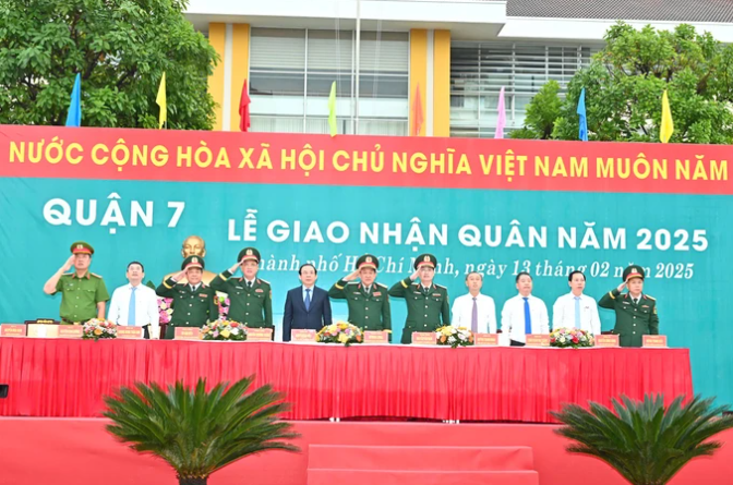 Bí thư Thành ủy TPHCM Nguyễn Văn Nên cùng các đồng chí lãnh đạo dự lễ giao, nhận quân điểm của TPHCM tại quận 7 thực hiện nghi thức chào cờ. Ảnh: VIỆT DŨNG