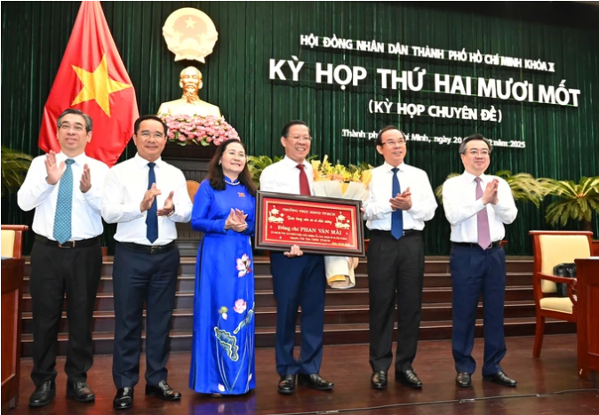 Bí thư Thành ủy TPHCM Nguyễn Văn Nên cùng các đồng chí Thường trực Thành ủy TPHCM tặng hoa và bức khánh để cảm ơn và chúc mừng đồng chí Phan Văn Mãi nhận nhiệm vụ mới. Ảnh: VIỆT DŨNG