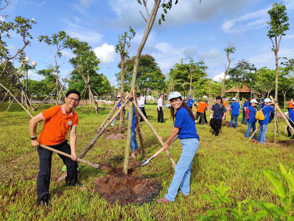 Ông Lê Văn Thu cùng kiều bào tham gia trồng cây. Ảnh: PHƯƠNG ĐẶNG tham-gia-trong-cay-2.jpg