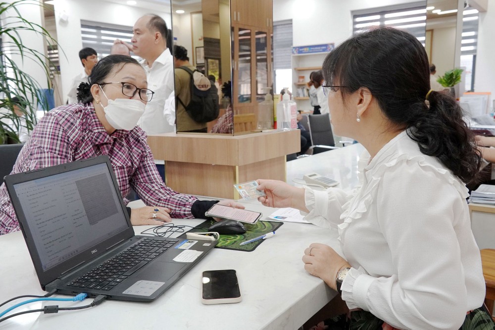 Công chức quận 11 tiếp nhận và giải quyết thủ tục hành chính cho người dân. Ảnh: THU HƯỜNG canbo.jpg
