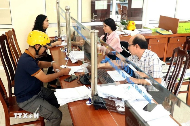 Người dân đến làm thủ tục hành chính tại Bảo hiểm xã hội tỉnh Hưng Yên. (Ảnh: Đinh Văn Nhiều/TTXVN) bao-hiem-27.jpg