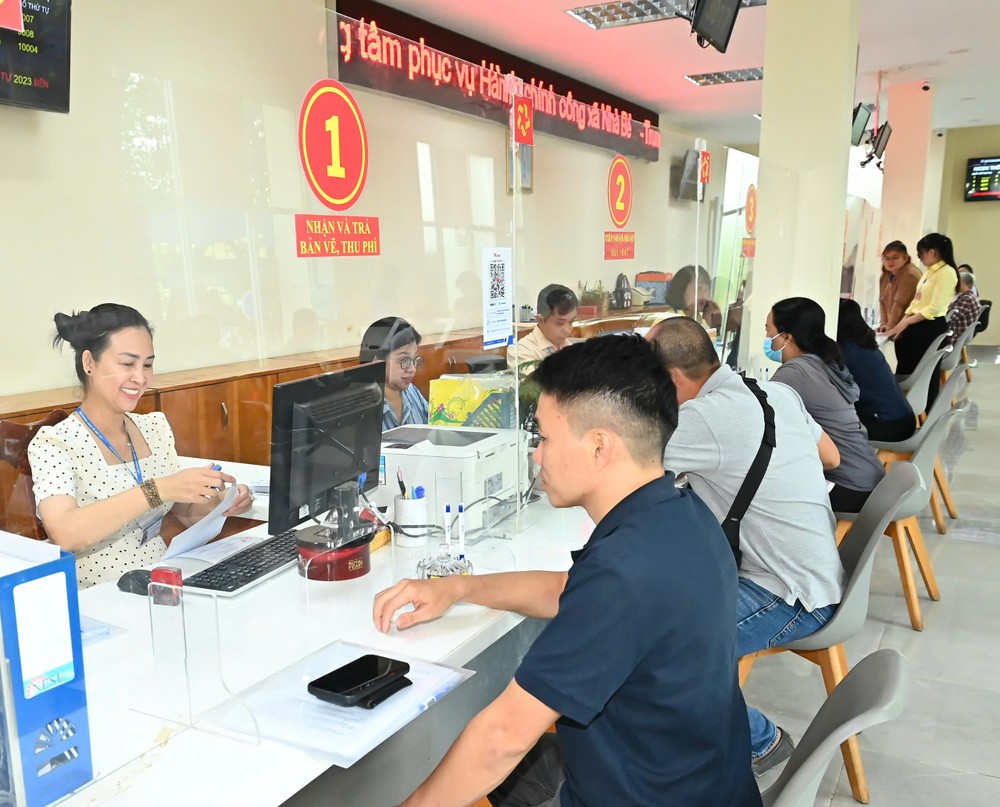 Công chức xã Nhà Bè tiếp nhận thủ tục hành chính của người dân. Ảnh: VIỆT DŨNG 17-7. 9.jpg