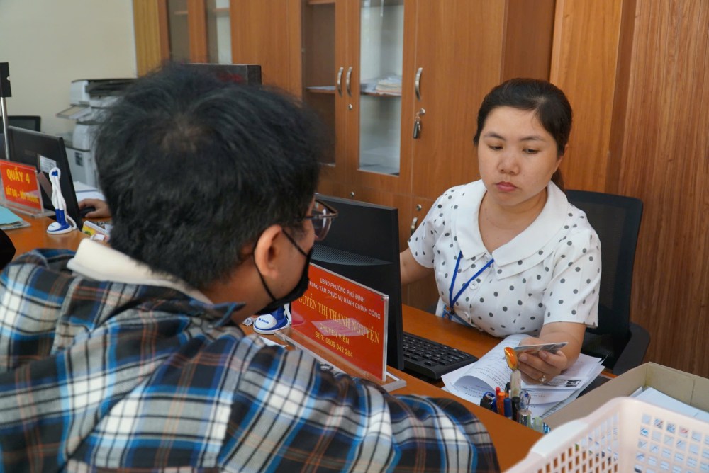 Cán bộ hỗ trợ tận tình cho người dân khi đến làm thủ tục. Ảnh: Minh Tâm