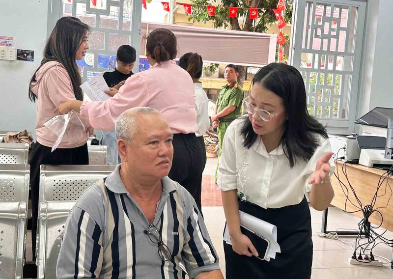 Cán bộ tại phường Tân Sơn Nhất hướng dẫn cho người dân đến làm thủ tục hành chính. Ảnh: Minh Tâm