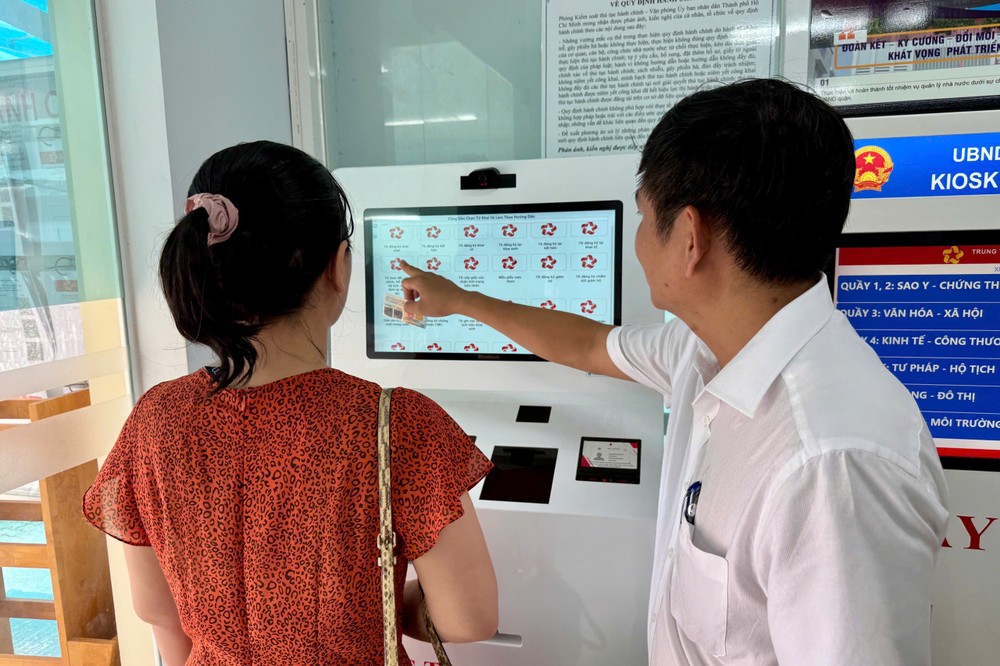 Chị Nguyễn Ngọc Thanh được ông Nguyễn Minh Thiện, Phó Chủ tịch UBND, Giám đốc Trung tâm Phục vụ hành chính công phường Tân Hưng, hướng dẫn sử dụng quét căn cước in tờ khai tại máy kiosk. Ảnh: HUỲNH THƠ IMG_1997.jpeg