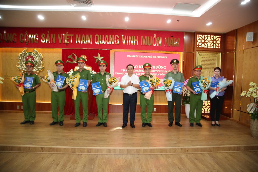 Đồng chí Nguyễn Văn Được trao thưởng và tặng hoa chúc mừng 4 tập thể và 4 cá nhân. Ảnh: CATP z6913698079122_039c403fa7c45d31de9ffa8c61f4d080.jpg