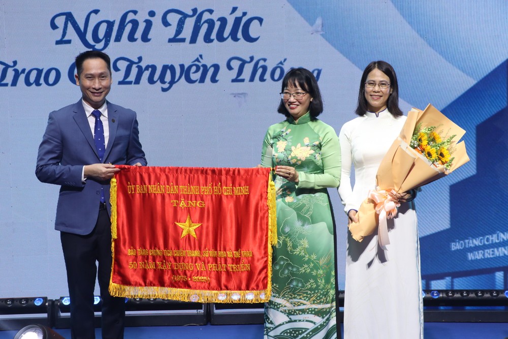 លោកស្រី Tran Thi Dieu Thuy អនុប្រធានគណៈកម្មាធិការប្រជាជនទីក្រុងហូជីមិញបានប្រគល់ទង់ប្រពៃណីដល់សារមន្ទីរសំណល់សង្គ្រាម។ រូបថត៖ V. HA bao-tang-chung-tich-chien-tranh3.JPG