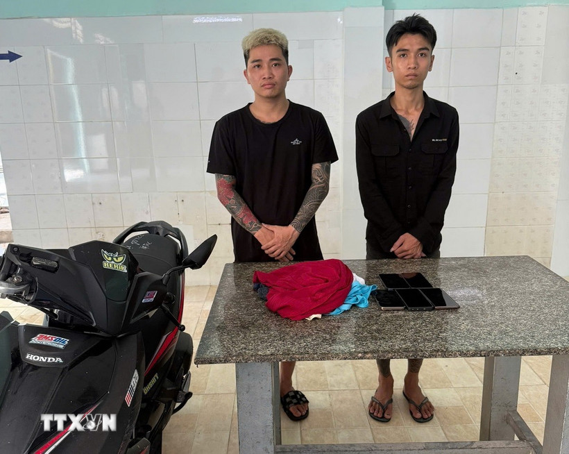 Hai đối tượng Lương Công Thuận và Lê Văn Nhâm tại cơ quan công an. (Ảnh: TTXVN phát)