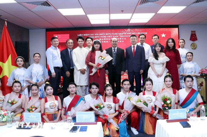 Các đại biểu chụp ảnh lưu niệm cùng các em sinh viên tham gia biểu diễn văn nghệ tại buổi gặp mặt. (Ảnh: Xuân Khu/TTXVN) ttxvn-tq-vn2.jpg