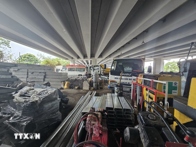 Dưới gầm cầu Lò Gốm tập kêt nhiều vật tư xây dựng dễ xảy ra nguy cơ cháy, nổ khi có sự cố. (Ảnh: Linh Sơn/ TTXVN)