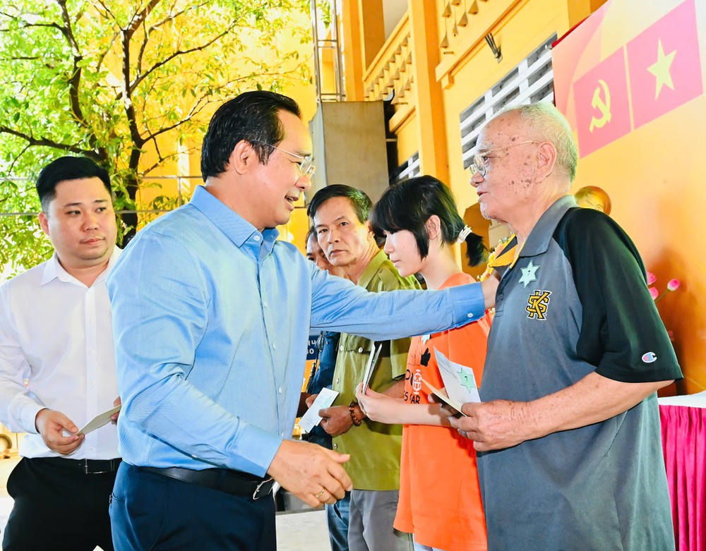 Chủ tịch UBND TPHCM trao các phần quà đến các hộ gia đình có hoàn cảnh khó khăn trên địa bàn phường nhân dịp chuẩn bị đón Tết cổ truyền của dân tộc. Ảnh: VIỆT DŨNG 2899575458784842330.jpg