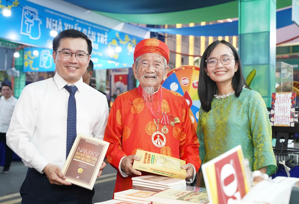 Nhà nghiên cứu Nguyễn Đình Tư (106 tuổi, đứng giữa), hào hứng tham quan các gian hàng tại Lễ hội Đường sách Tết Bính Ngọ 2026. Ảnh: THUẬN VĂN đường sách tết (1).jpg