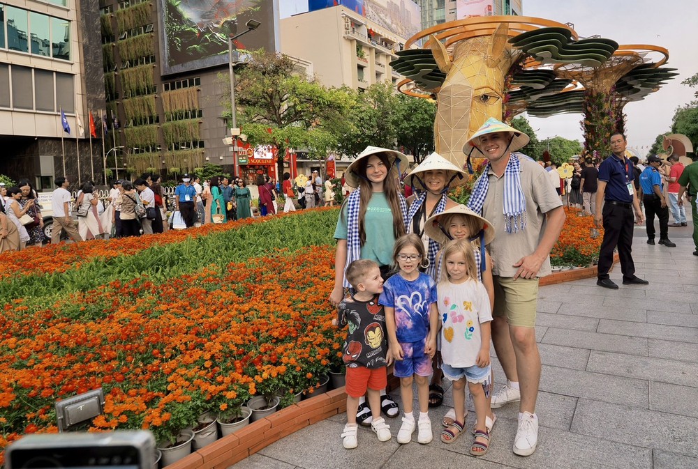 Khách tham quan đường hoa Nguyễn Huệ, chiều 21-2. Ảnh: HOÀNG HÙNG Khách quốc tế tham quan đường hoa.jpg