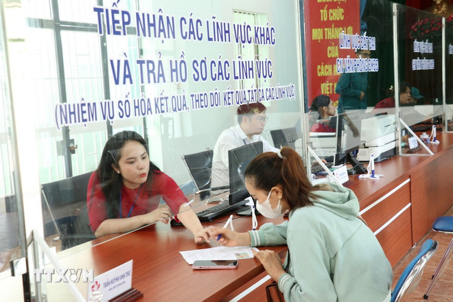Hướng dẫn người dân làm thủ tục đăng ký hộ kinh doanh. (Ảnh: Dương Chí Tưởng/TTXVN) ttxvn-dang-ky-ho-kinh-doanh.jpg
