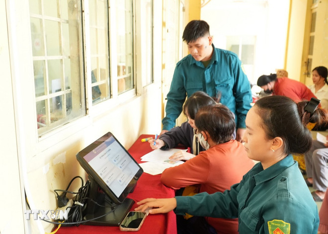 Lực lượng dân phòng ở xã Thái Mỹ, Thành phố Hồ Chí Minh, tham gia hướng dẫn người dân làm thủ tục dịch vụ công trực tuyến. (Ảnh: Hữu Duyên/TTXVN) ttxvn-xa-thai-my-chinh-quyen-2-cap.jpg