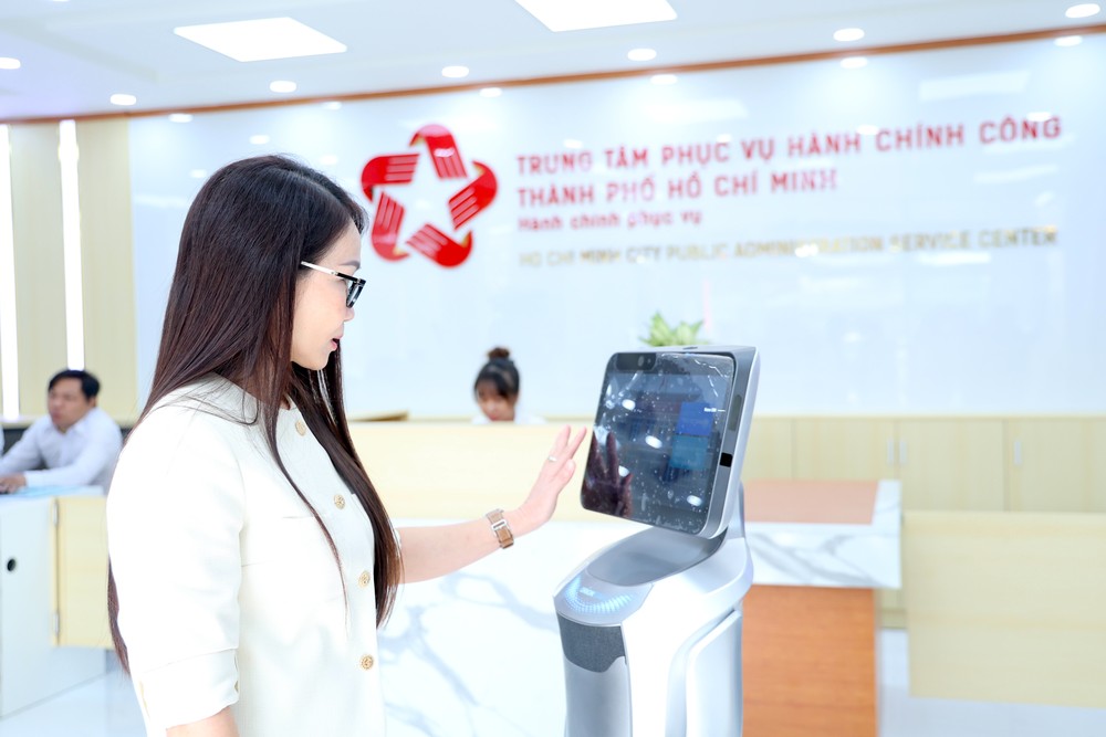 Người dân trải nghiệm robot phục vụ khi đến làm thủ tục tại Trung tâm phục vụ hành chính công TP.HCM. Ảnh: LÊ THOA Thành ủy TP.HCM: Dữ liệu số là tài nguyên chiến lược để bảo đảm an ninh mạng -an-ninh-mang-ai-du-lieu-ai-le-thoa.JPG