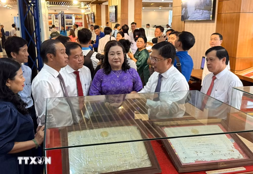 Các đại biểu tham quan triển lãm. (Ảnh: Hữu Duyên/TTXVN) ttxvn-ho-so-khen-thuong-khang-chien-chong-phap-1.jpg