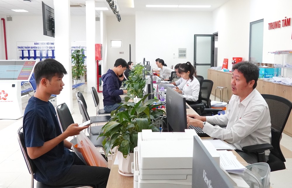 Chuyên viên Trung tâm Phục vụ hành chính công phường Cát Lái tiếp và giải quyết thủ tục hành chính cho người dân. Ảnh: THU HƯỜNG ok 1.JPG
