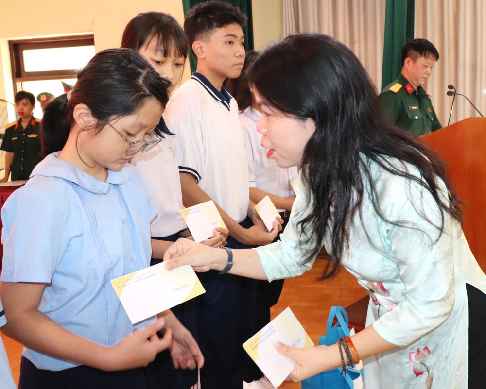 Chủ tịch Hội LHPN TPHCM Nguyễn Thị Ngọc Xuân trao học bổng đến trẻ mồ côi, hiếu học. Ảnh: THÁI PHƯƠNG traoqua.jpg